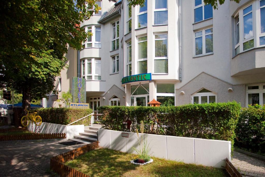 柏林阿特兰提卡酒店的前面有白色围栏的白色建筑