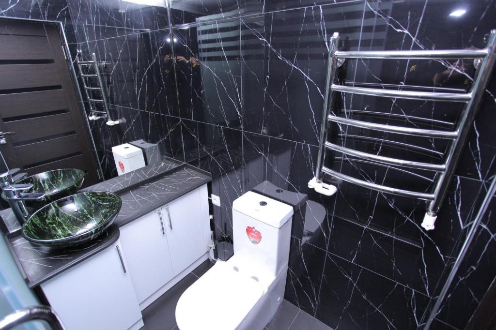 撒马尔罕Overlooking Registan Square Luxury 2 Bedrooms Apartment的一间带卫生间的浴室和黑色瓷砖墙