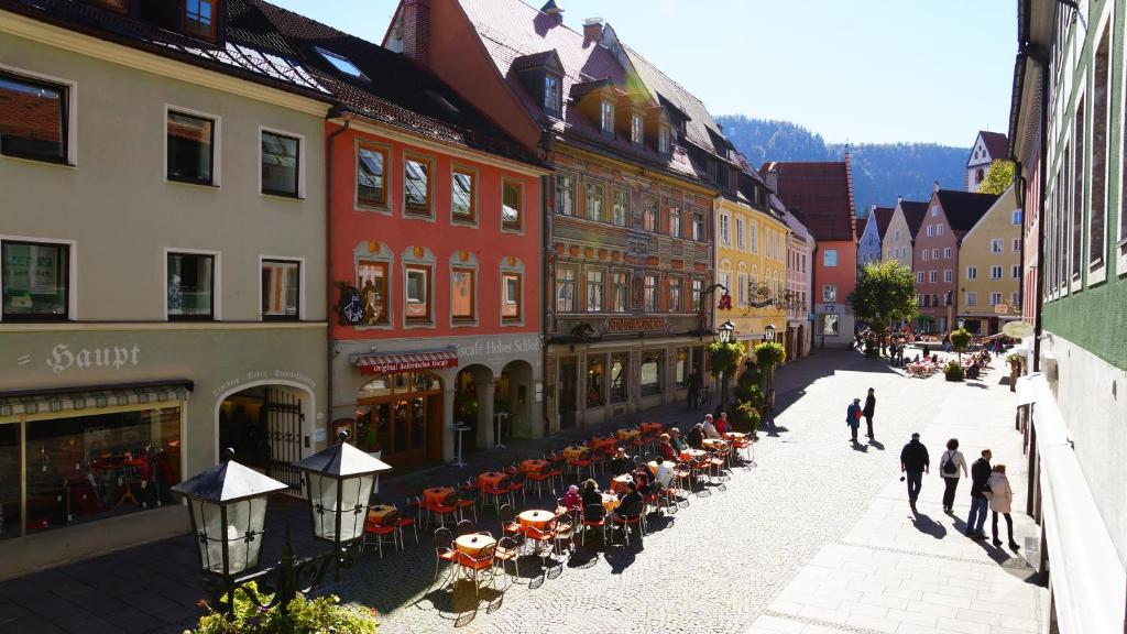 福森巴伐利亚城市旅舍 - 设计旅舍的一群人沿着街道走着,街道上有许多建筑