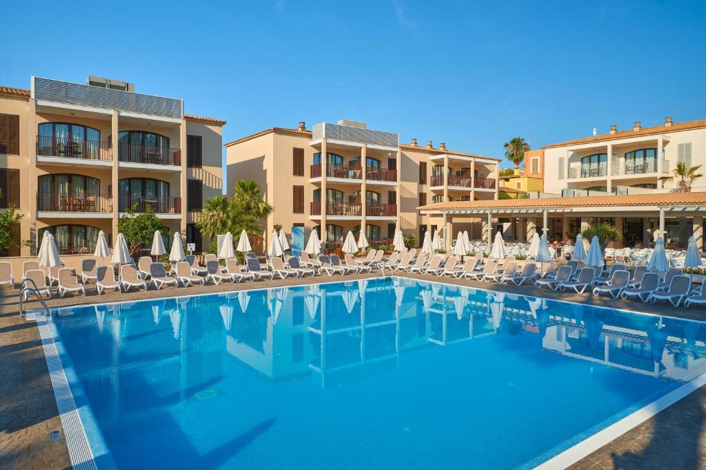 卡拉博纳Protur Floriana Resort 3* SUP的度假村内带椅子和遮阳伞的游泳池