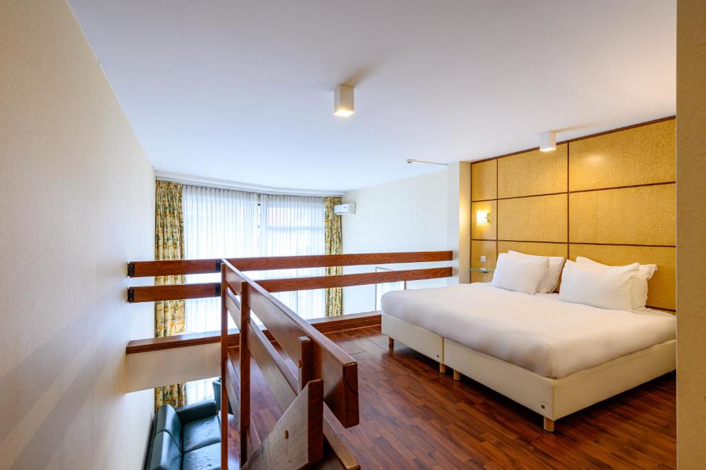 布鲁塞尔蒙哥马利B公寓式酒店的卧室配有白色的床和楼梯。