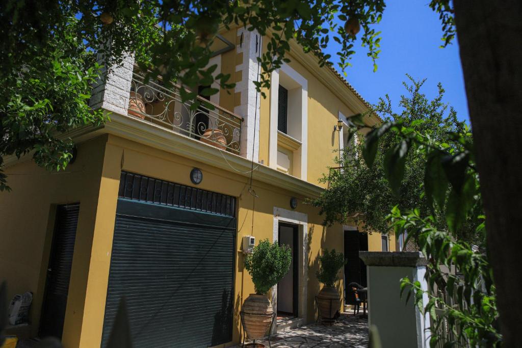 帕莱罗斯Palairos historic property的黄色房子,有黑色车库门