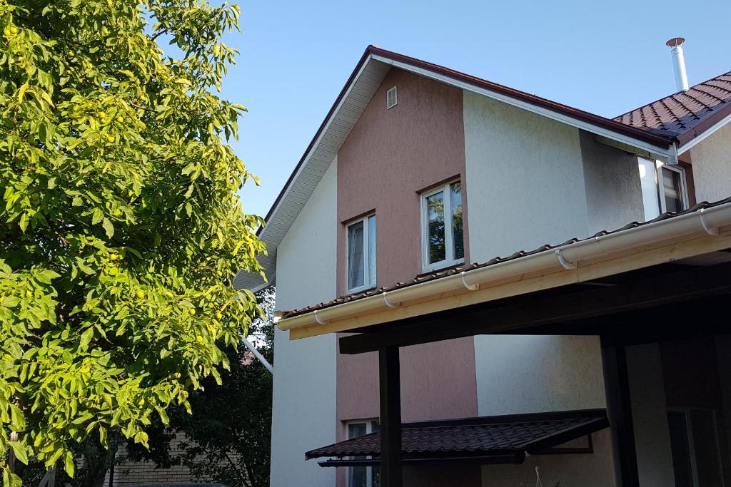 HoraGoraTwins guest house near Boryspil airport的前面有一棵树的房子