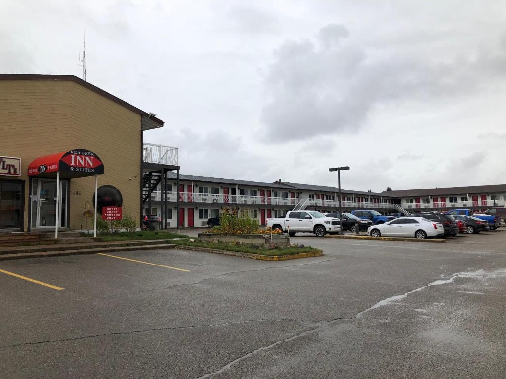 雷德迪尔Red Deer Inn & Suites的停车场,停车场停在大楼前