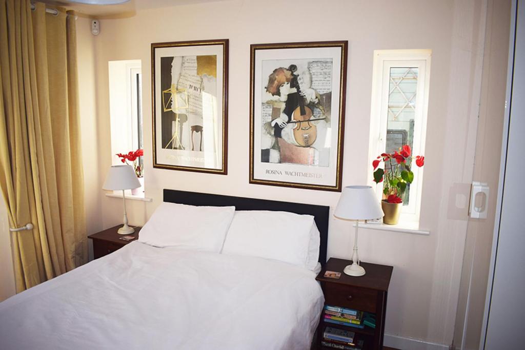 奥克姆Wings的卧室配有一张床,墙上有三幅照片