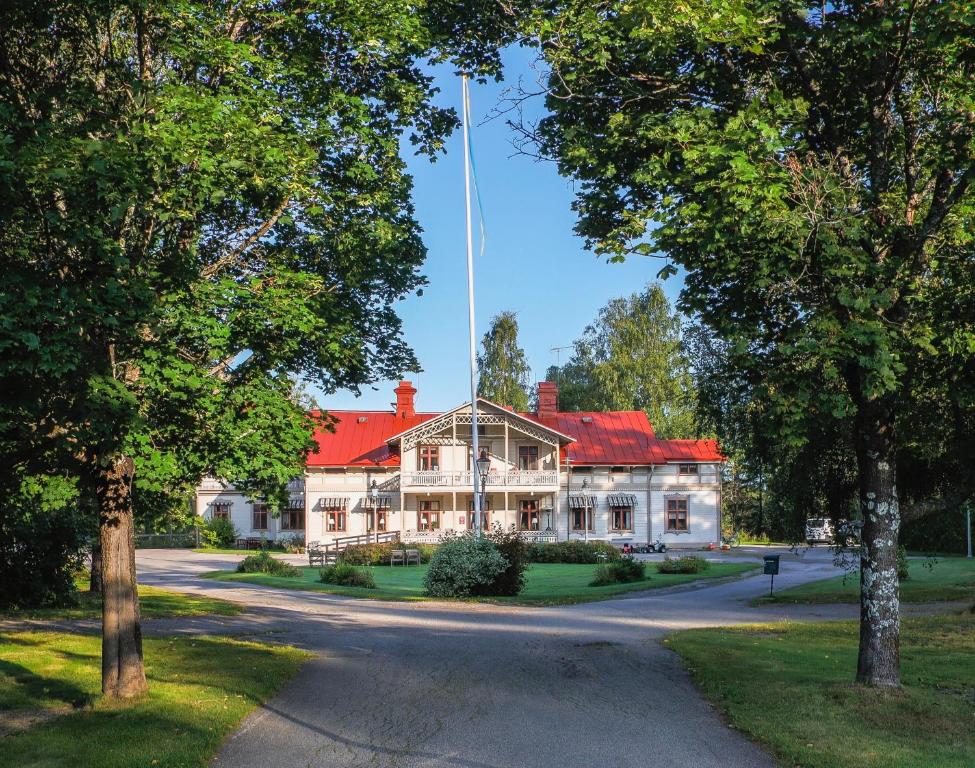 于斯达尔Borrgården Hostel的一座大型白色房屋,设有红色屋顶