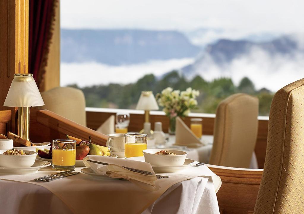 肯图巴Mountain Heritage Hotel的一张带食品和饮料的桌子,享有山景