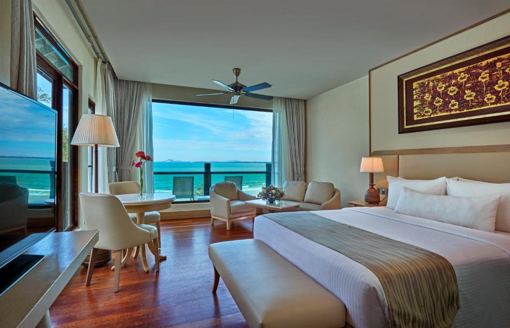 珍拉丁Royale Chulan Cherating Villa的酒店客房设有一张床和一个大窗户