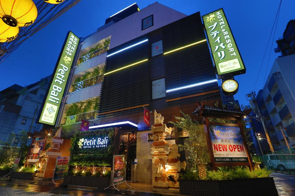 东京HOTEL PetitBali Higashi-Shinjuku的前面有 ⁇ 虹灯标志的建筑