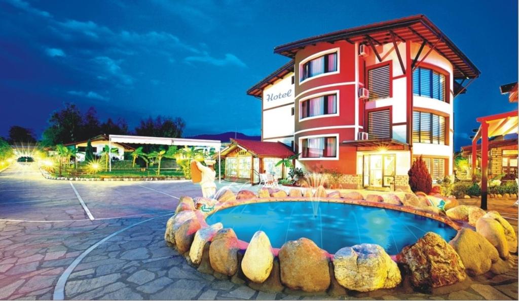 莫姆奇尔格勒马卡匝大厦旅馆的一座带游泳池的度假村,位于一座建筑前