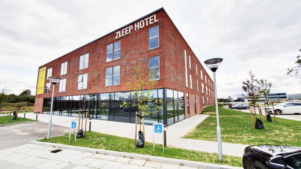 奥胡斯Zleep Hotel Aarhus Skejby的红砖建筑,上面有标志
