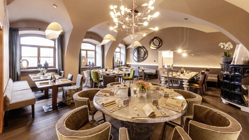 马希特伦克Hotel Gasthof Fischer的一间带桌椅和吊灯的餐厅