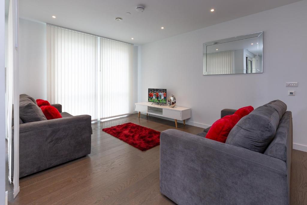 伦敦伦敦中央豪华公寓的客厅设有两张沙发,配有红色枕头