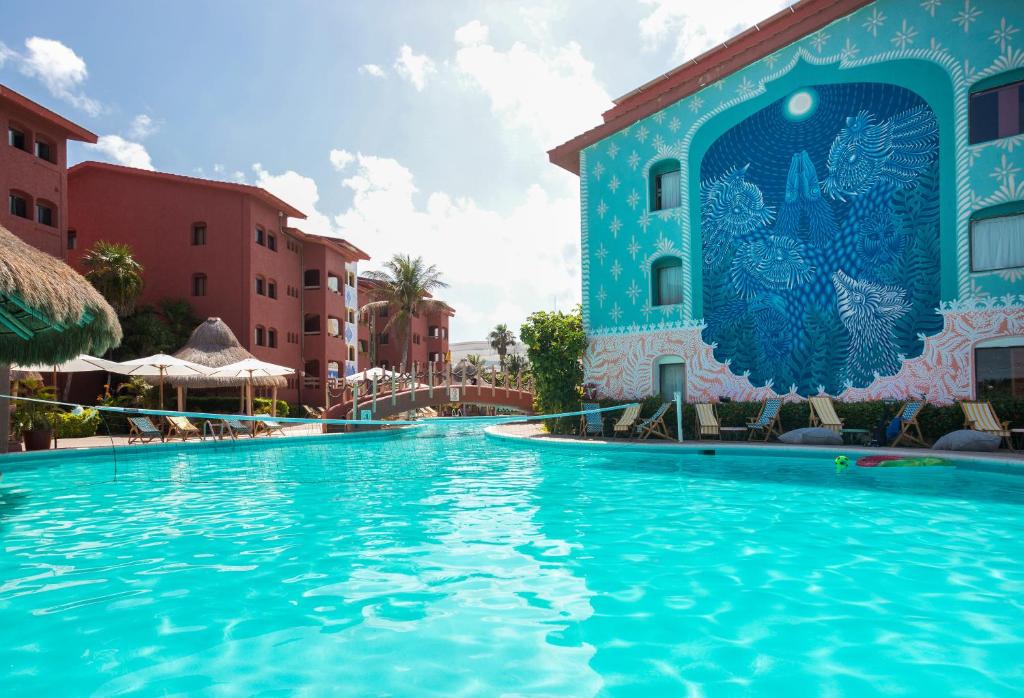 坎昆Selina Cancun Laguna Hotel Zone的蓝色建筑度假村的游泳池