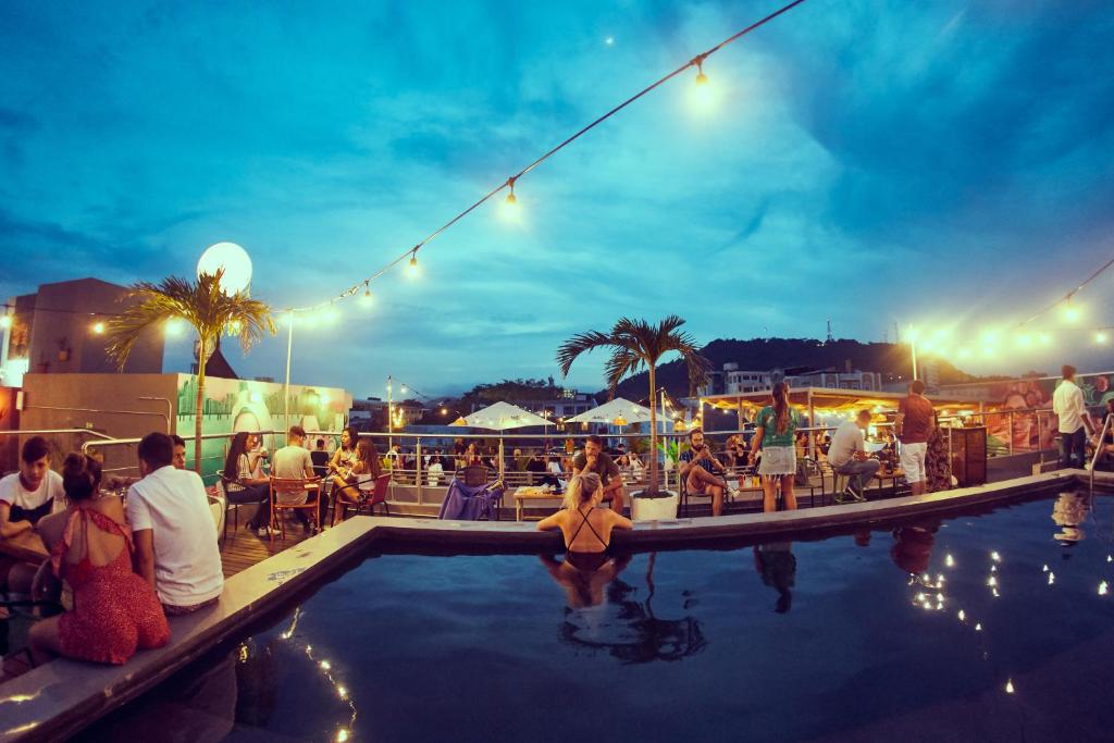 巴拿马城Selina Casco Viejo Panama City的一群人晚上坐在游泳池周围