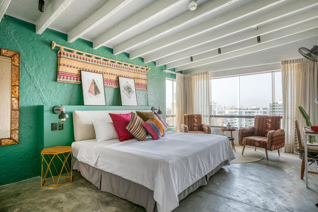 利马利马米拉弗洛尔塞丽娜酒店的一间卧室设有一张大床和绿色的墙壁