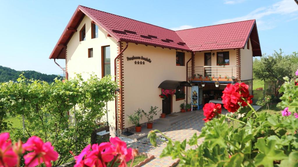 MustăţeştiPensiunea Luminita的一座红色屋顶和鲜花的房子