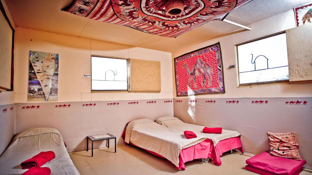 迪莫纳内格夫加美尔牧场旅舍的客房设有两张床、一张桌子和窗户。