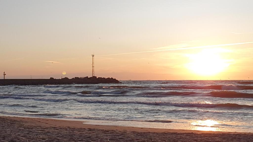 克莱佩达Guest House Gero Vėjo Namai的海滩上的日落和日落