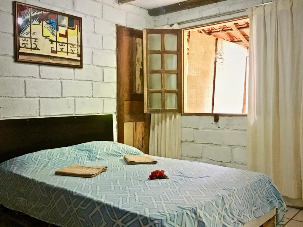 塞古罗港Quitinetes Rusticas Junto a Natureza - Bruxas e Bruxos的一间卧室配有带2条毛巾的床和窗户。
