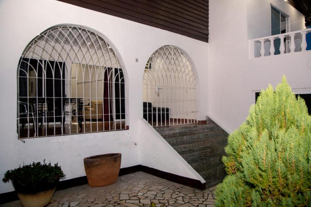 帕拉马里博玛雅公寓的白色的建筑,有两座拱门和一些植物