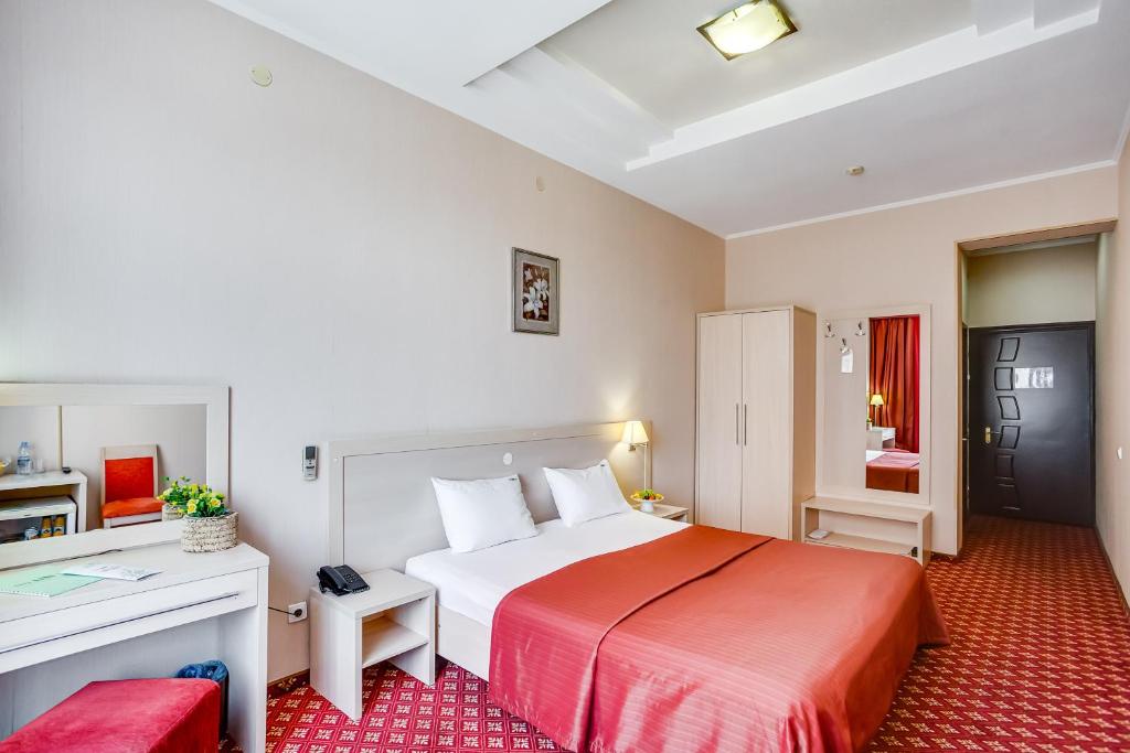 顿河畔罗斯托夫城市公园酒店的酒店客房设有一张大床和一张书桌。