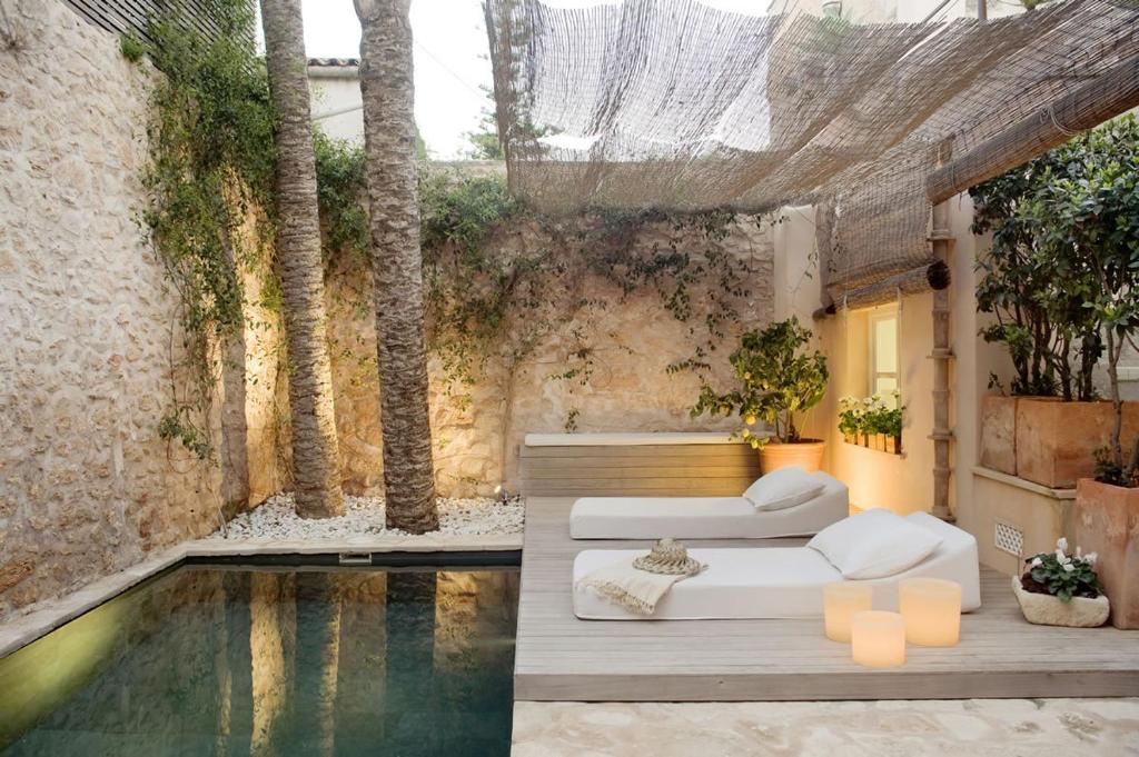 桑坦伊S'Hotelet de Santanyi的客房设有游泳池、沙发和桌子。