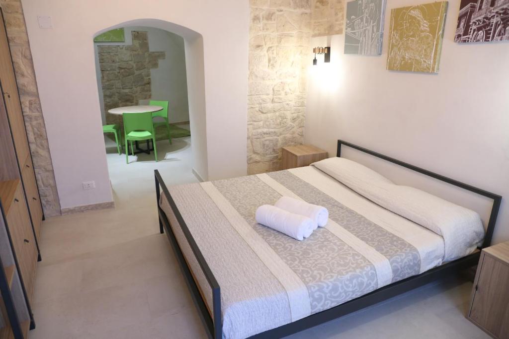 特拉尼Locus Pendinelli Trani的一间卧室配有一张带白色枕头的床