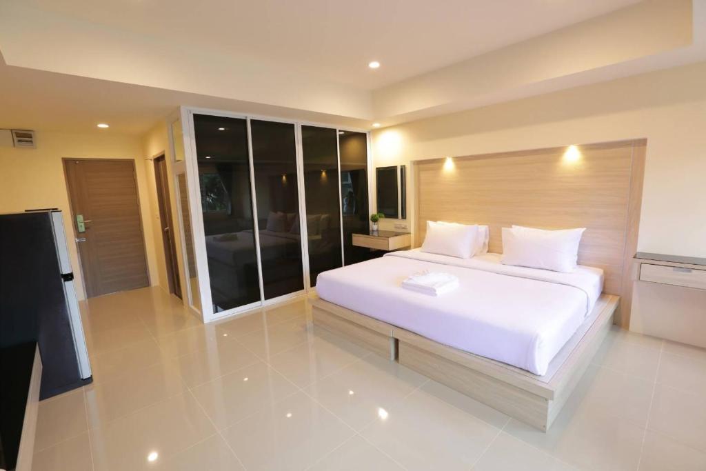 南邦Lampang Residence的卧室配有一张白色大床和电视。