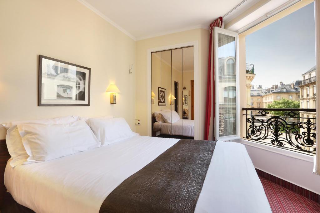 巴黎法兰西学院酒店的一间卧室设有一张大床和一个大窗户