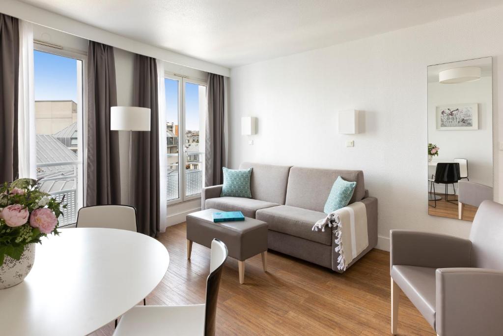 巴黎馨乐庭巴黎马莱巴士底狱酒店的客厅配有沙发和桌子