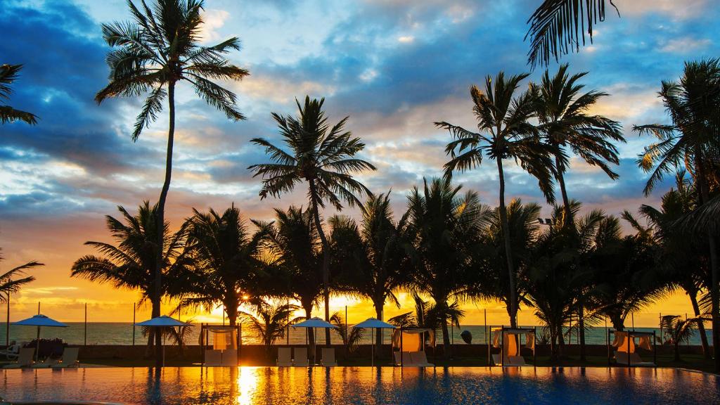 马塞约Jatiuca Hotel & Resort的棕榈树度假村和日落美景