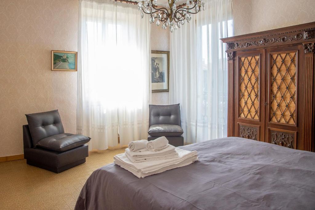 拉莫拉Bed & Roses Meni的一间卧室配有一张带两把椅子的床和吊灯。