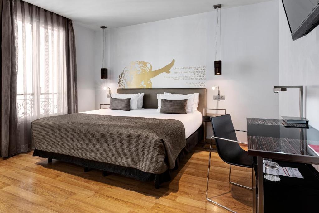 巴黎埃克斯全景酒店的一间卧室配有一张大床和一张书桌