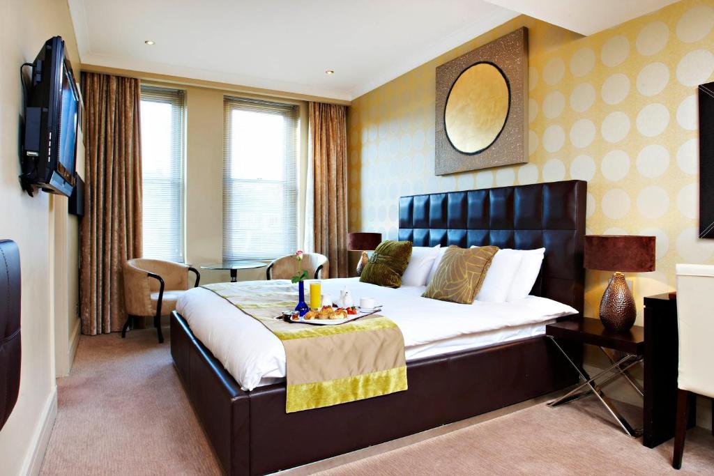 伦敦世界华盛顿梅菲尔酒店的一间卧室配有一张大床,上面放着一盘食物