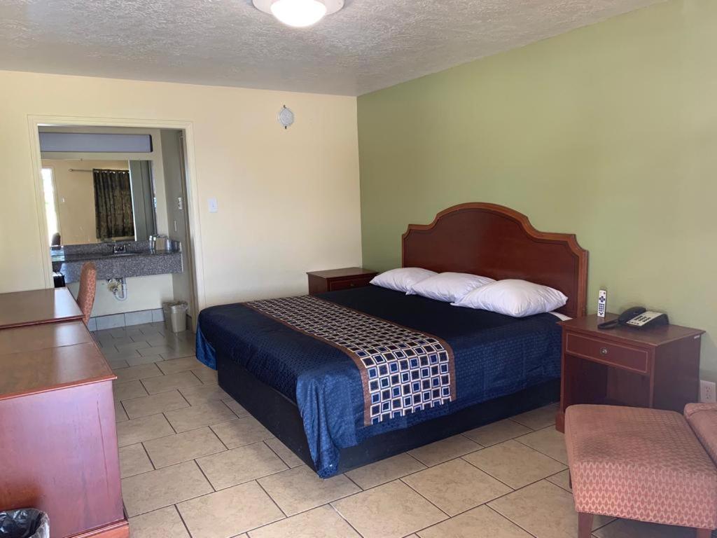 博蒙特得克萨斯州博蒙特旅馆的配有一张床和一把椅子的酒店客房