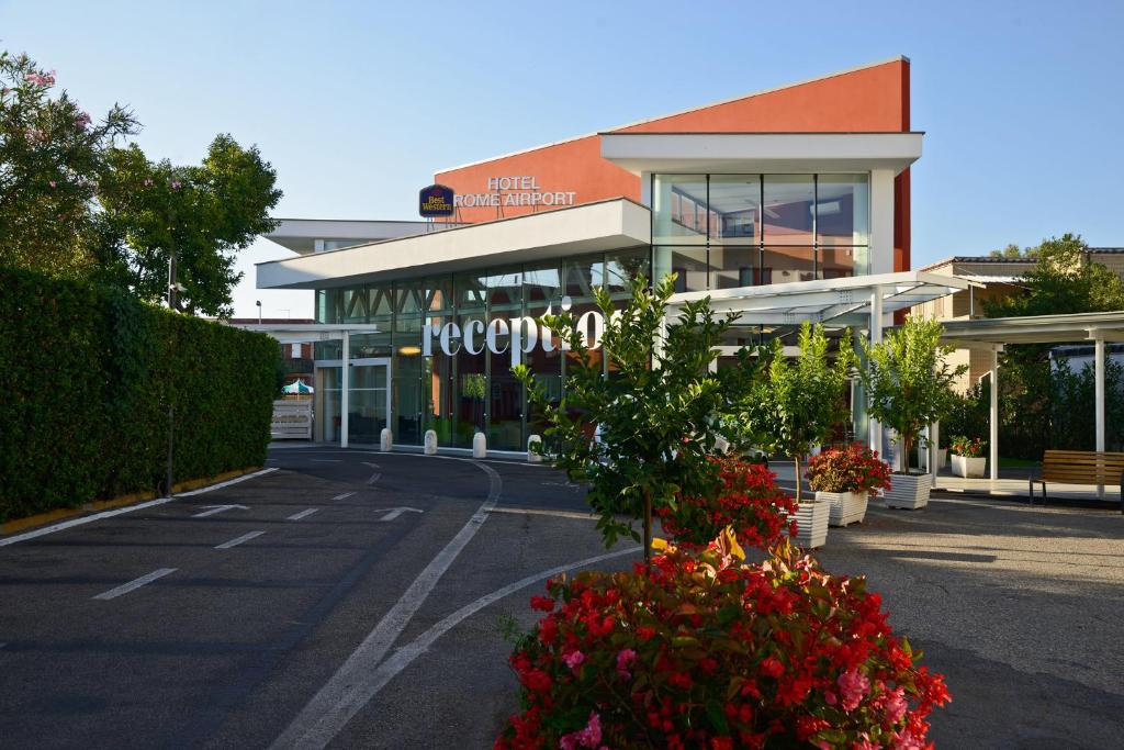 菲乌米奇诺罗马机场贝斯特韦斯特酒店的一座购物中心,在一座建筑前有鲜花
