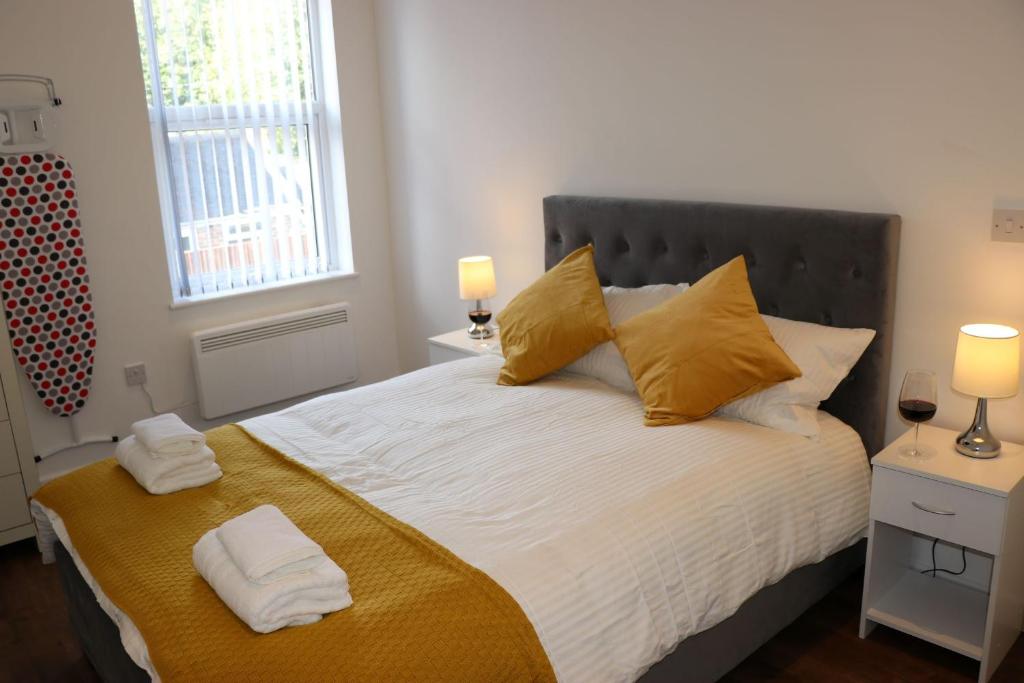特伦特河畔斯托克Modern Newgate Apartments - Convenient Location, Close to All Local Amenities的一间卧室配有一张带黄色枕头的大床