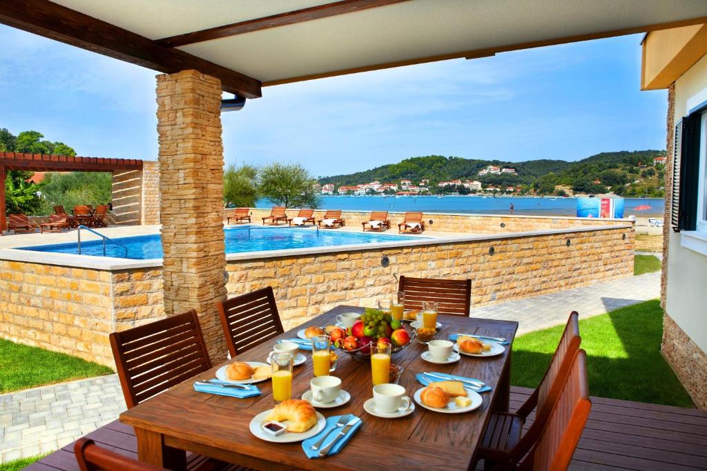 拉布兰多公寓度假酒店的一个带游泳池的庭院里一张带食物的木桌