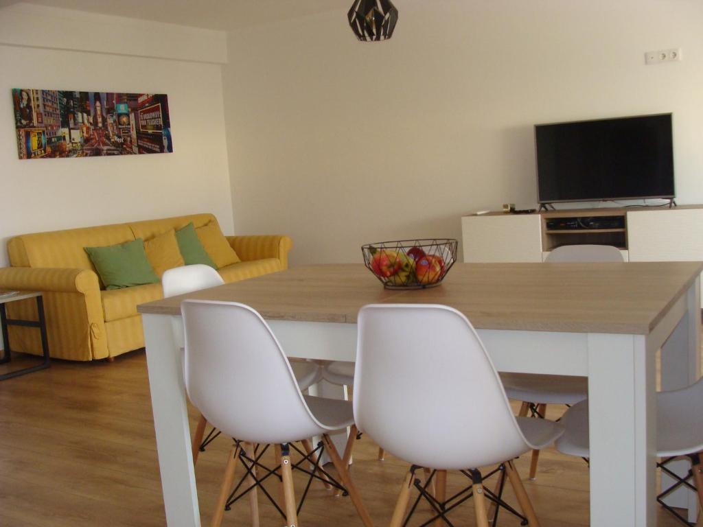 法鲁Casa do Largo的客厅配有桌子和白色椅子
