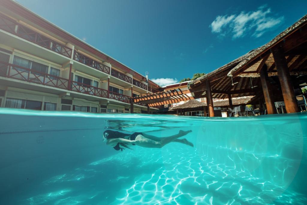维拉港卡维缇汽车旅馆的在酒店前的水中游泳的人