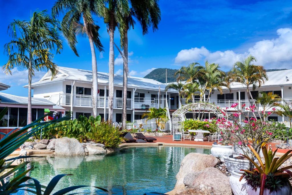 凯恩斯South Cairns Resort的一个带游泳池和棕榈树的度假村