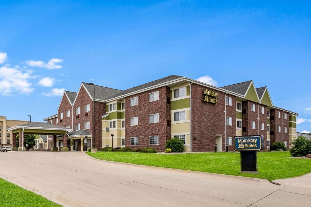 锡达拉皮兹MainStay Suites Cedar Rapids North - Marion的一座大型砖砌建筑,前面有标志