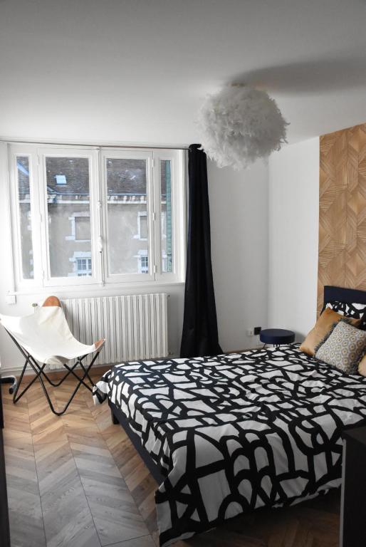 布雷斯地区布尔格LE SELECT DE BROU的一间卧室配有一张床、一把椅子和窗户。