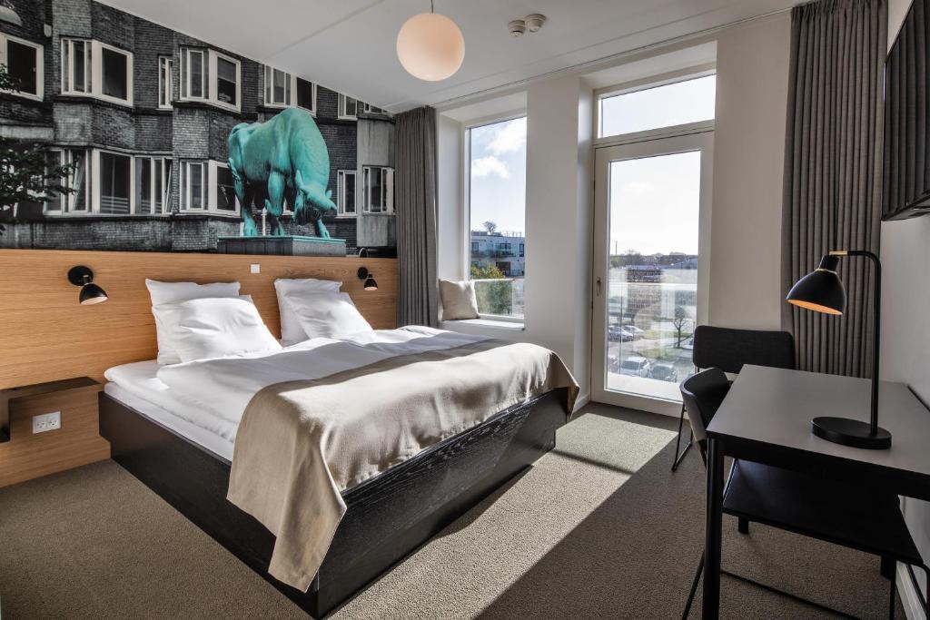 奥尔堡KOMPAS Hotel Aalborg的配有一张床和一张书桌的酒店客房