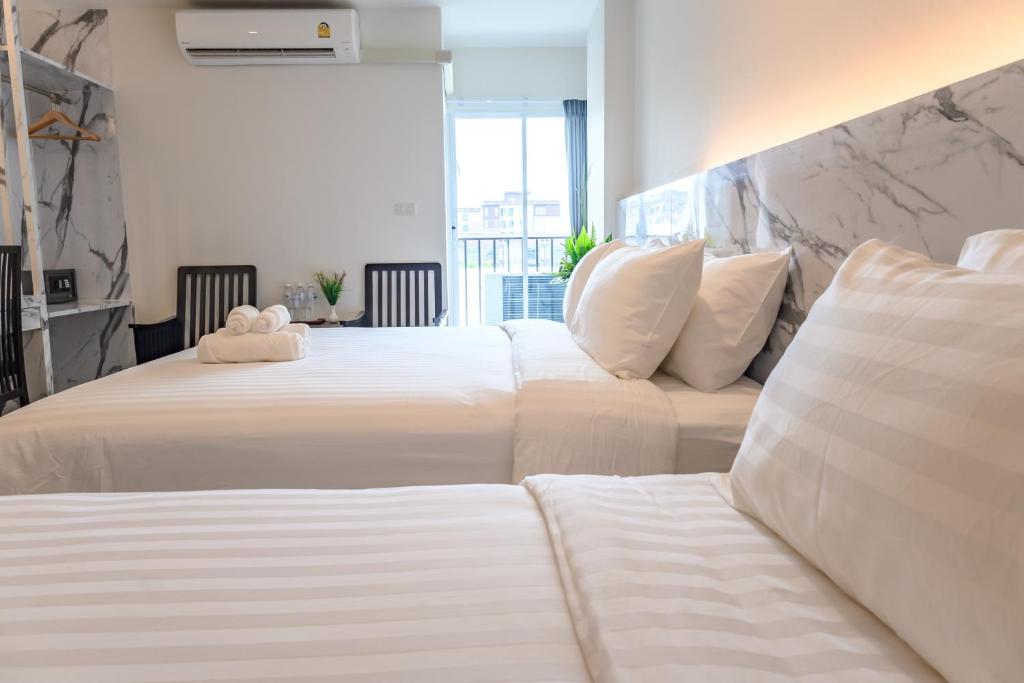 曼谷Donmueang Place Hotel - SHA Plus的两间位于酒店客房的床,上面有泰迪熊