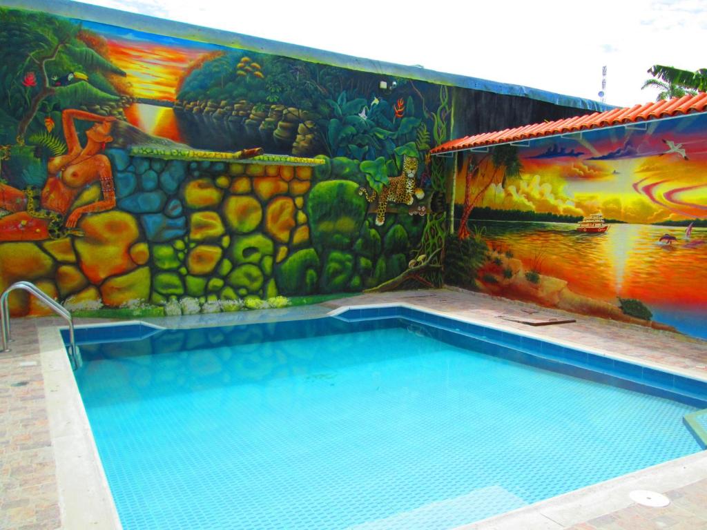 莱蒂西亚Hotel Huito的一座建筑的一侧,设有一座带壁画的游泳池