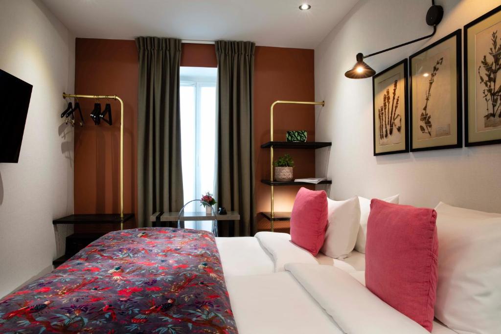 巴黎Hôtel Maxim Quartier Latin的客厅配有带粉红色枕头的白色沙发