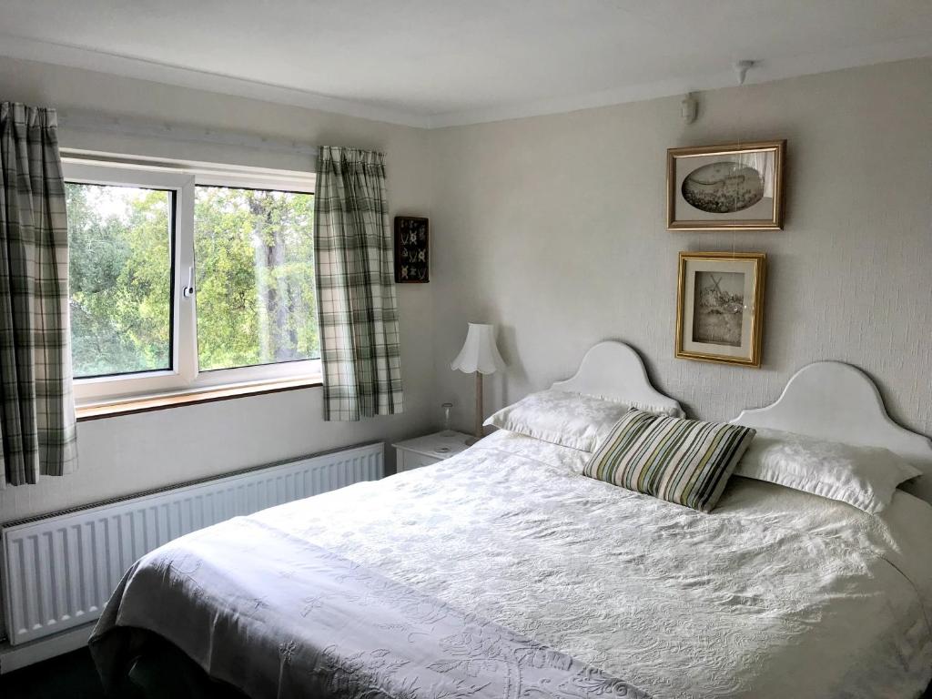 锡廷伯恩Holly House B&B的卧室配有白色的床和2扇窗户。