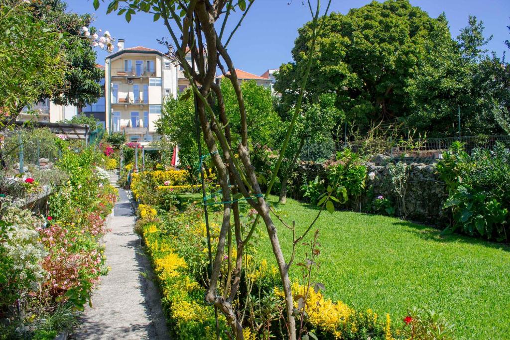 波尔图埃斯托里尔波尔图酒店的鲜花盛开的花园以及背景建筑